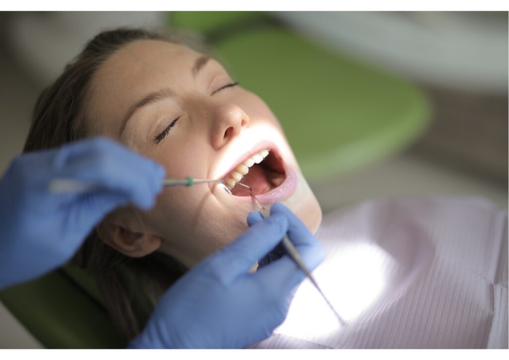 Patient receiving a dental examination while discussing dental implant pros and cons with a dentist