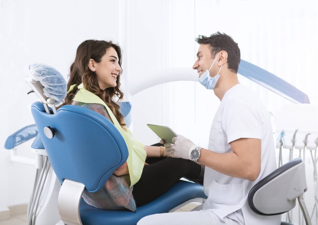 Patient discussing dental concerns with a dentist during an exam, helping identify what a cavity looks like and when treatment may be needed.