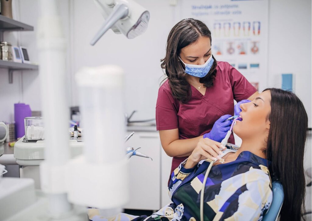 Dentist examining a patient during a dental visit to identify signs of a rotten tooth, including decay, discoloration, and damaged tooth structure.