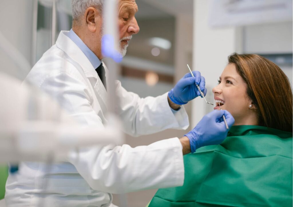 Dentist examining a patient during an oral evaluation to identify signs of an infected tooth, including pain, swelling, and gum inflammation.