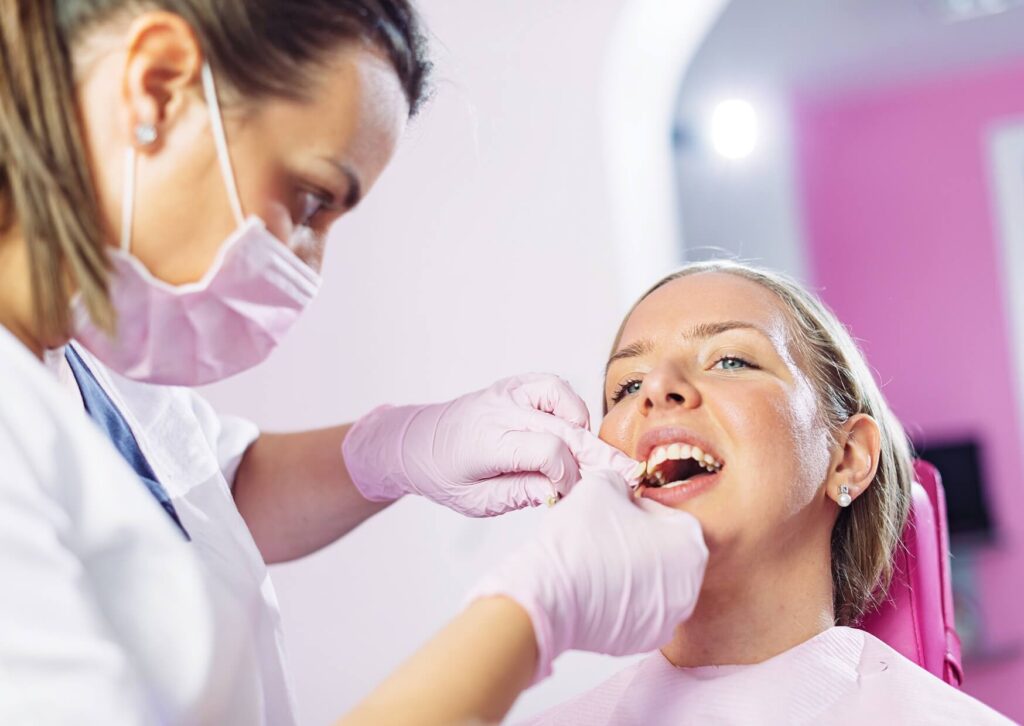 Dentist applying professional whitening treatment to a patient's teeth, demonstrating one of the available teeth whitening options.