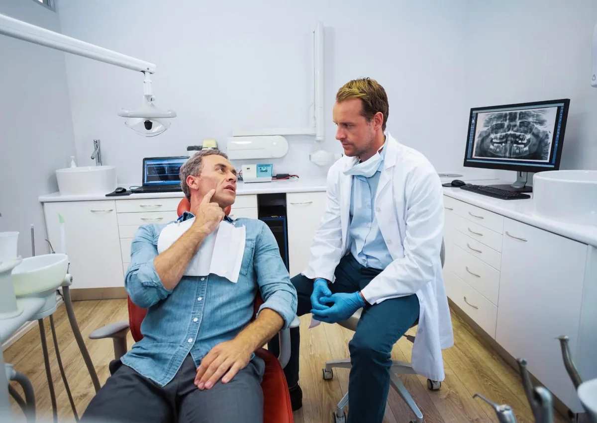 Patient discussing tooth pain with a dentist during an evaluation for possible cavities and tooth decay.