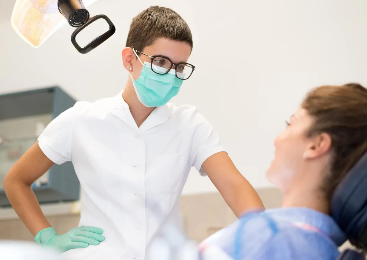Dentist discussing post-surgery instructions with a patient about avoiding dairy after dental implant surgery.