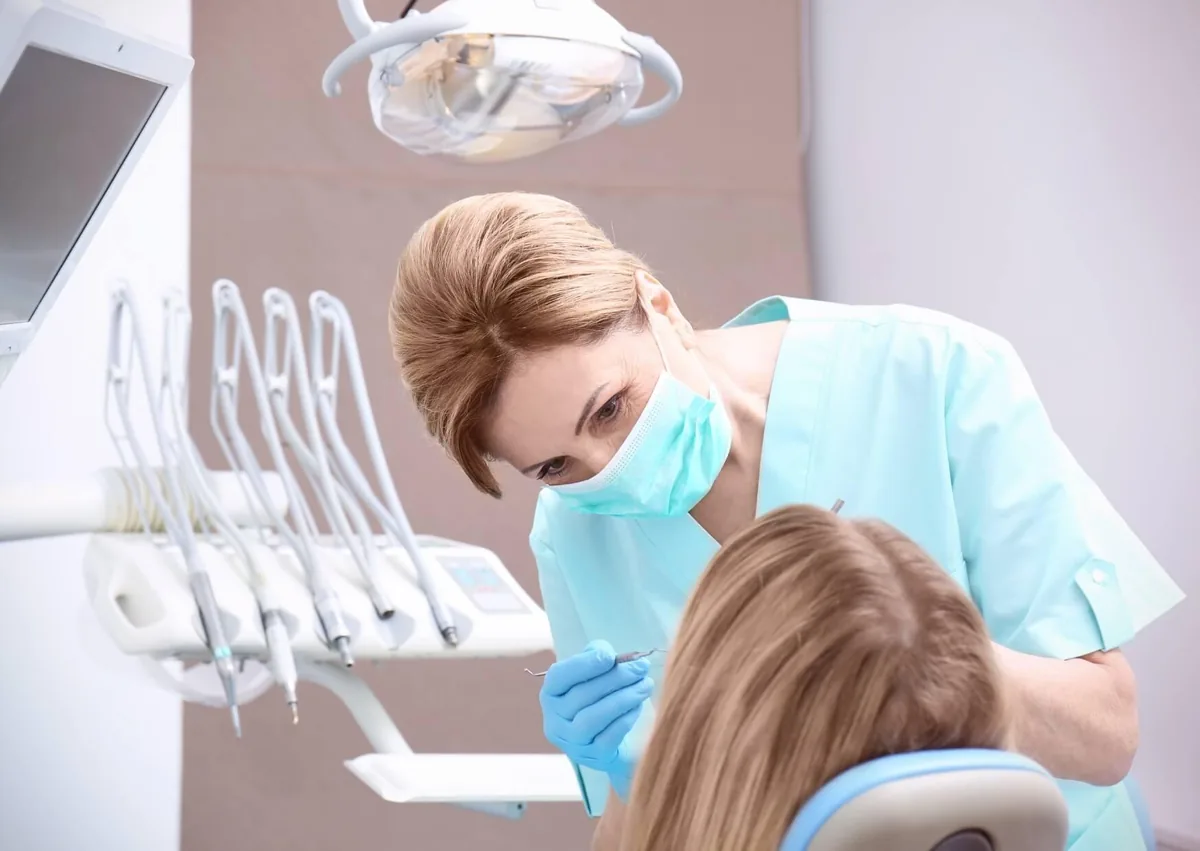 Dentist examining a patient's teeth for signs of early tooth decay to assess cavity formation and oral health.